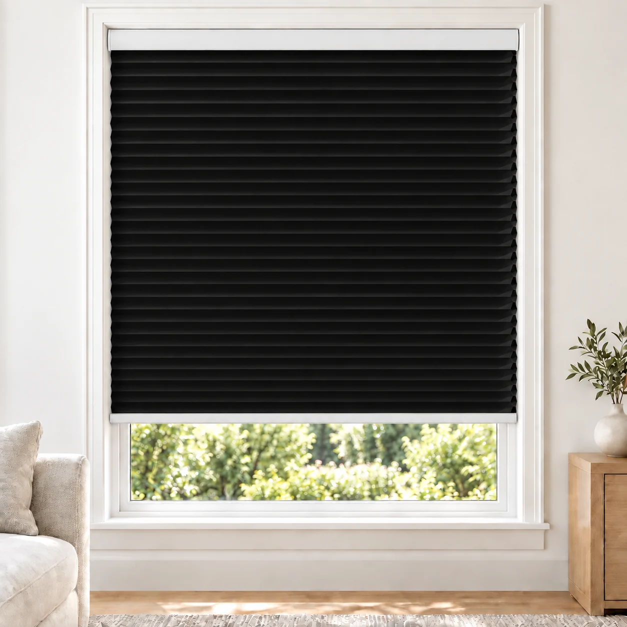 Onyx Black 25mm honeycomb cellular blind in a bright neutral living room, fabric B10, blackout