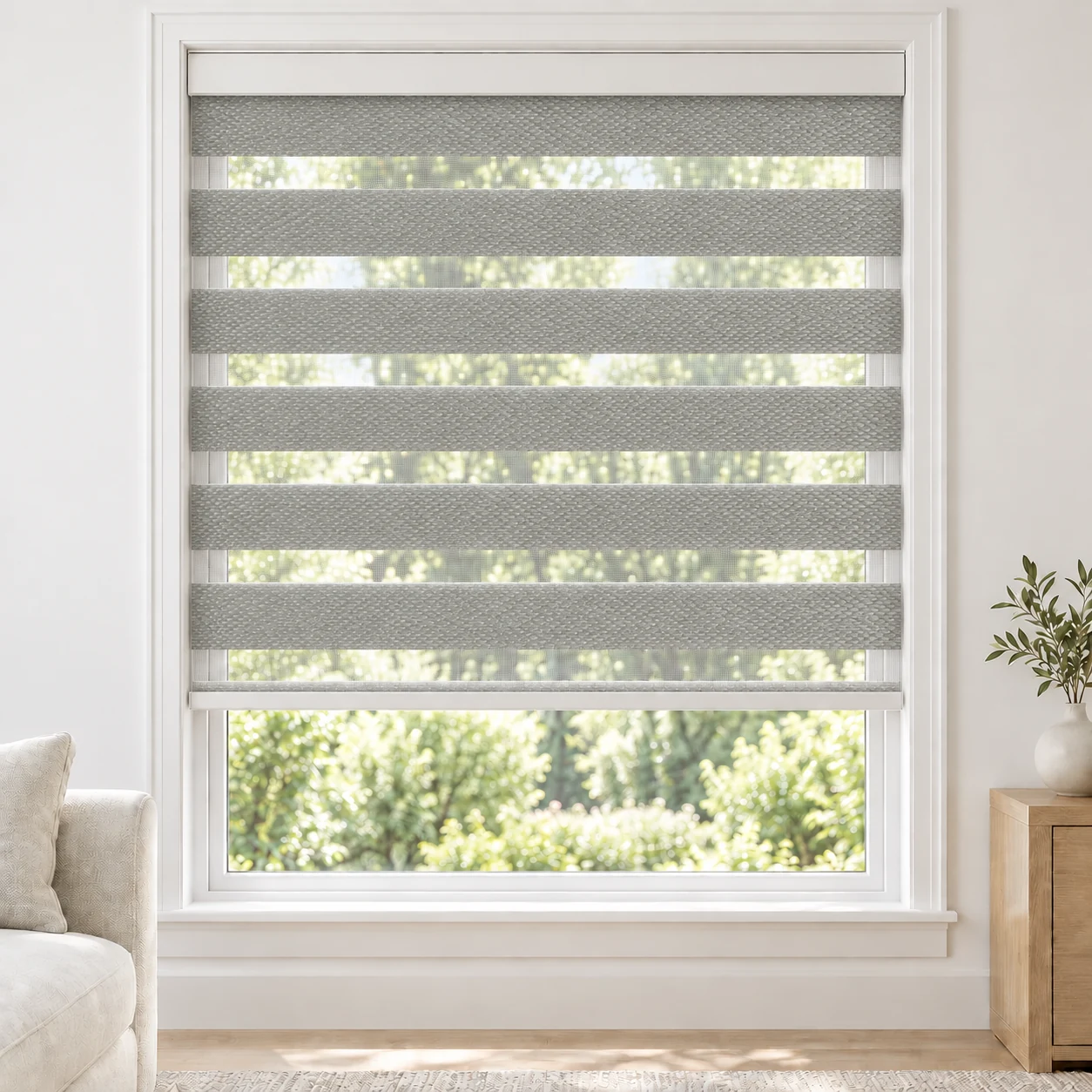 Silver Grey MILAN standard zebra blind with alternating fabric and sheer bands in a bright living room, MILAN-SLIVER-BO